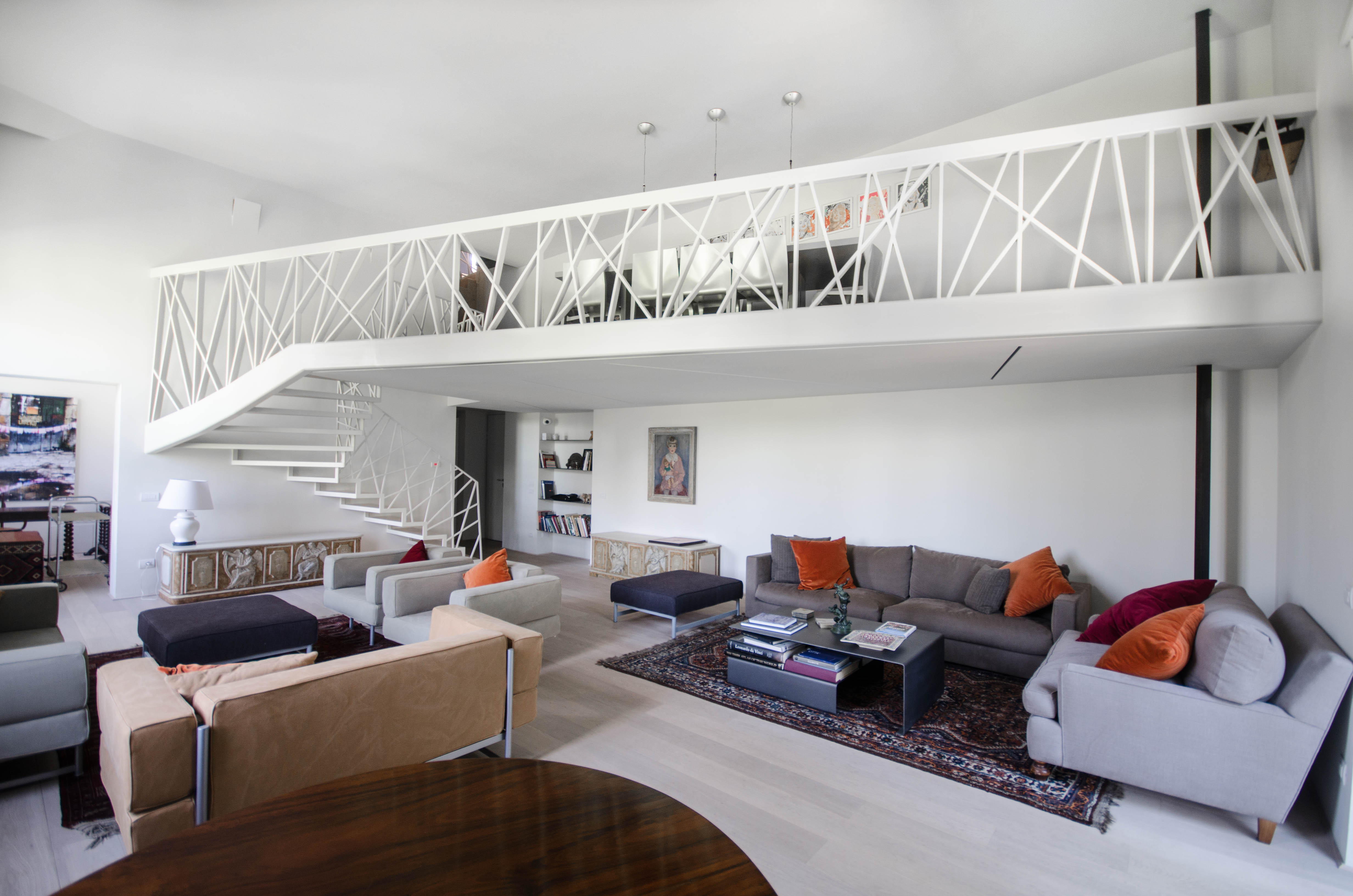 Double‑height living space with metal mezzanine in Rome apartment